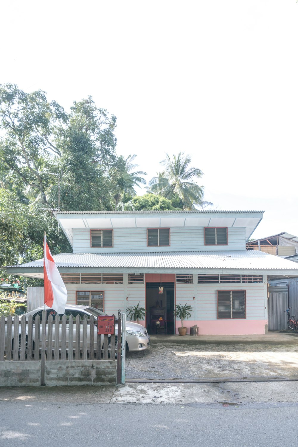 Maison en bois blanc et brun près des arbres verts pendant la journée