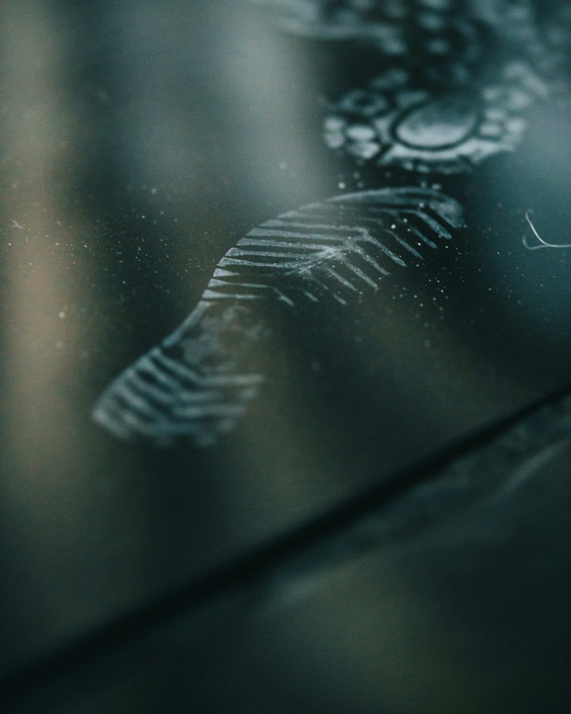 A close-up of a magnifying glass focusing on a set of footprints in a dusty alleyway.