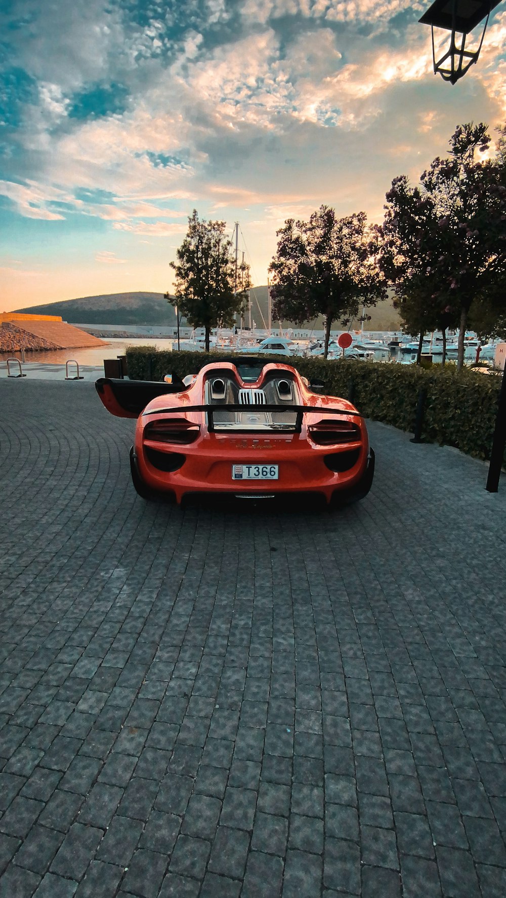 Auto Ferrari rossa parcheggiata su un marciapiede di cemento grigio