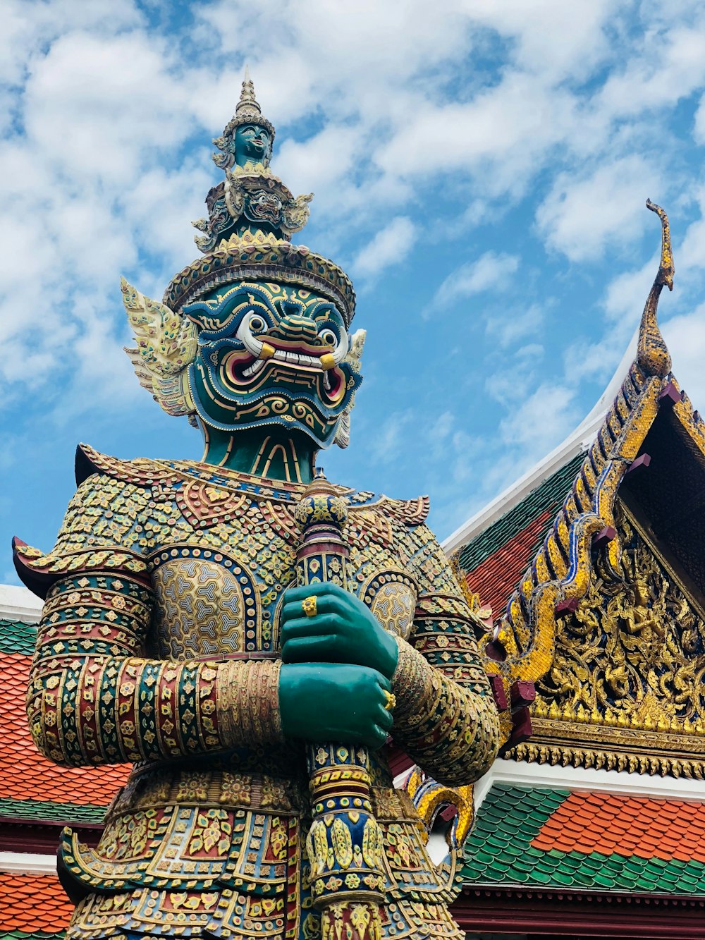 Estatua de dragón dorado y azul bajo el cielo azul durante el día