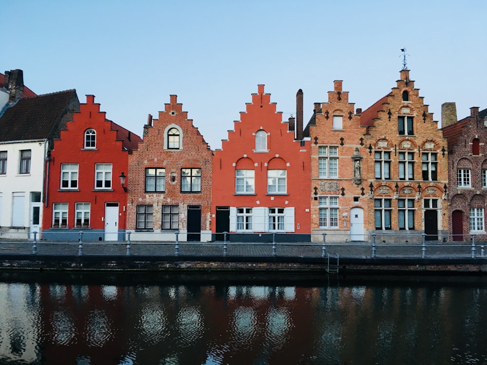 Bâtiment en béton rouge et blanc à côté d’un plan d’eau pendant la journée