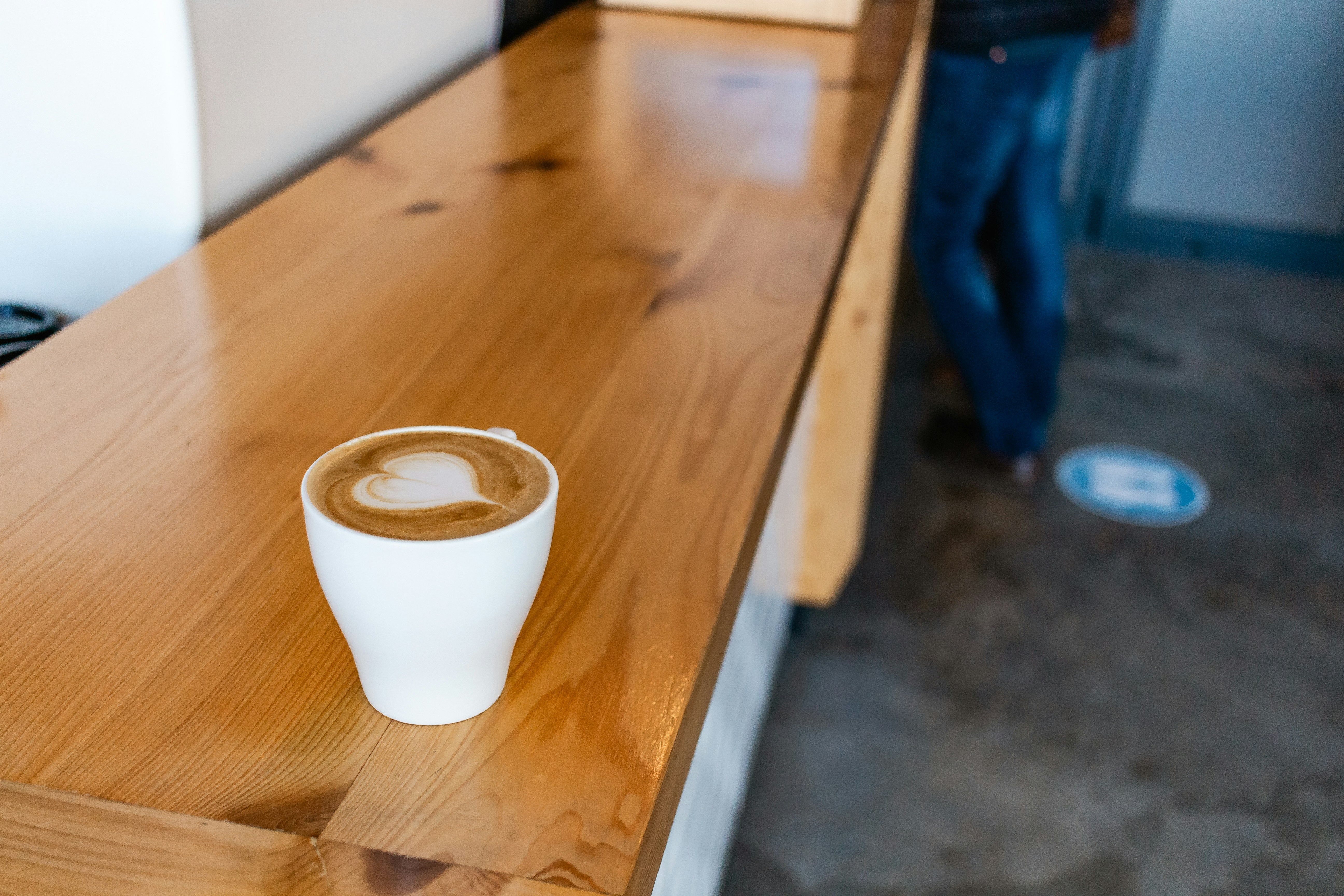 Small coffee on a long timber cafe bench