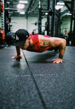 Person doing push-ups on a gym floor with focused expression.