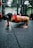 A man doing push-ups in a bright living room with fitness gear nearby.