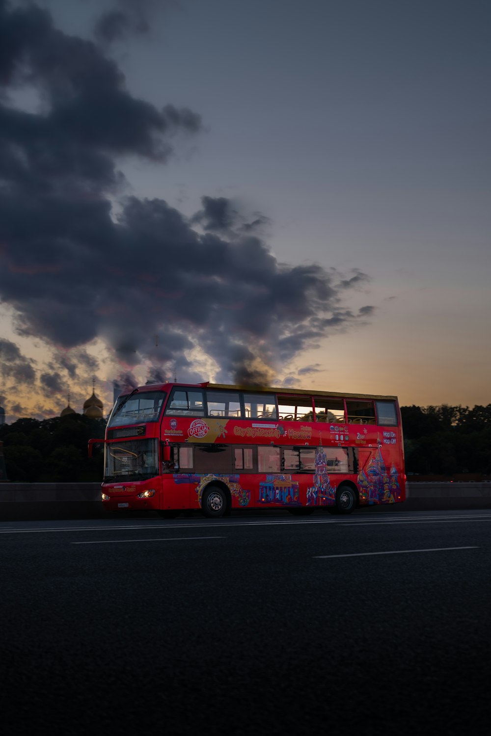 bus à impériale rouge sur la route sous un ciel nuageux pendant la journée