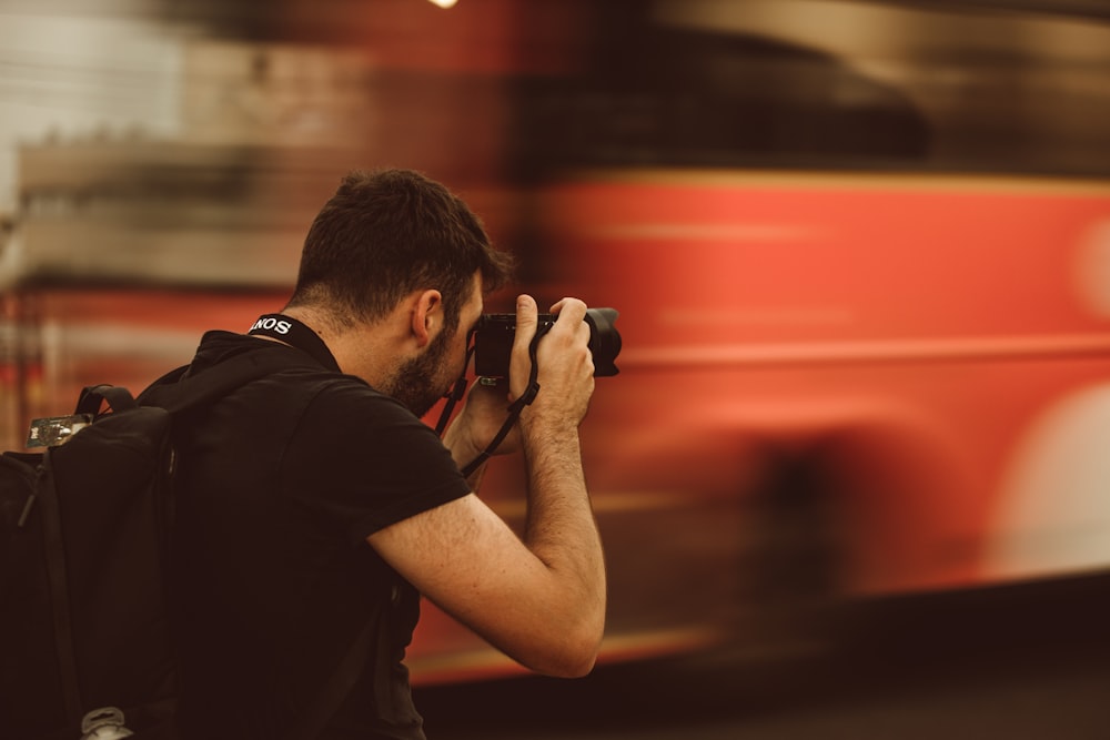 man in black t-shirt holding black camera