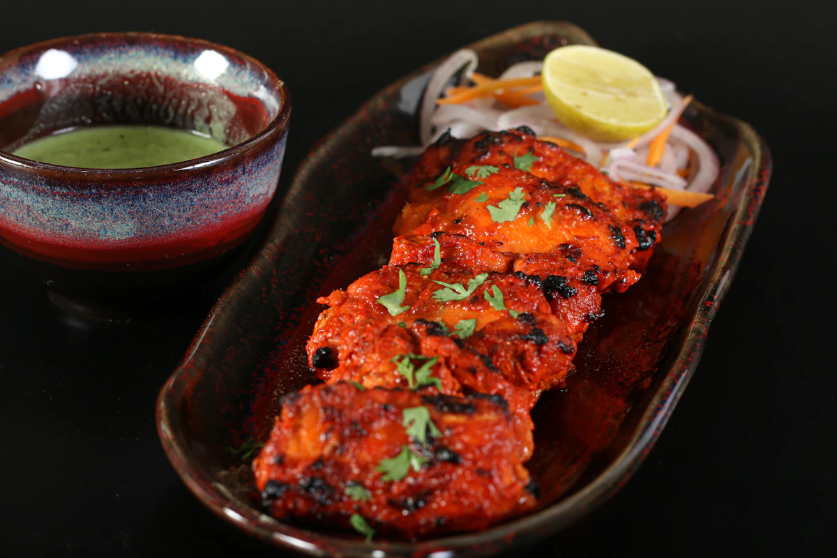 Fish tikka: red Kashmiri-chilli and ajwain marinated fillets, char-grilled and plated with green chutney, lemon and onion slaw
