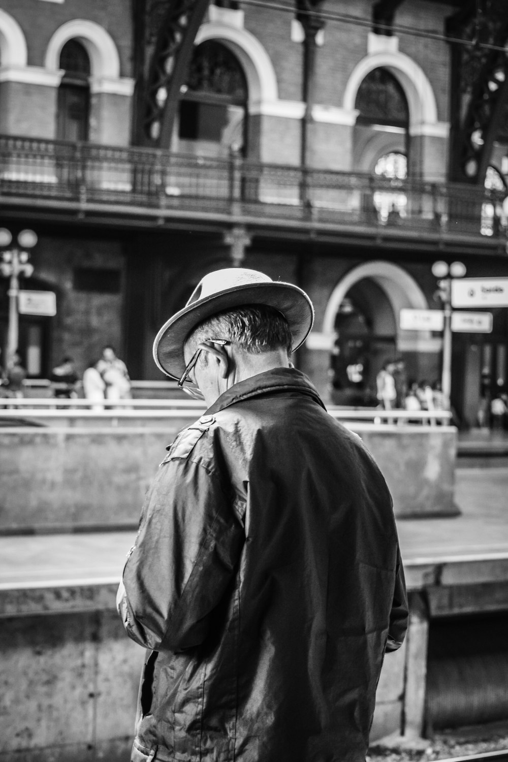grayscale photo of man in jacket and hat