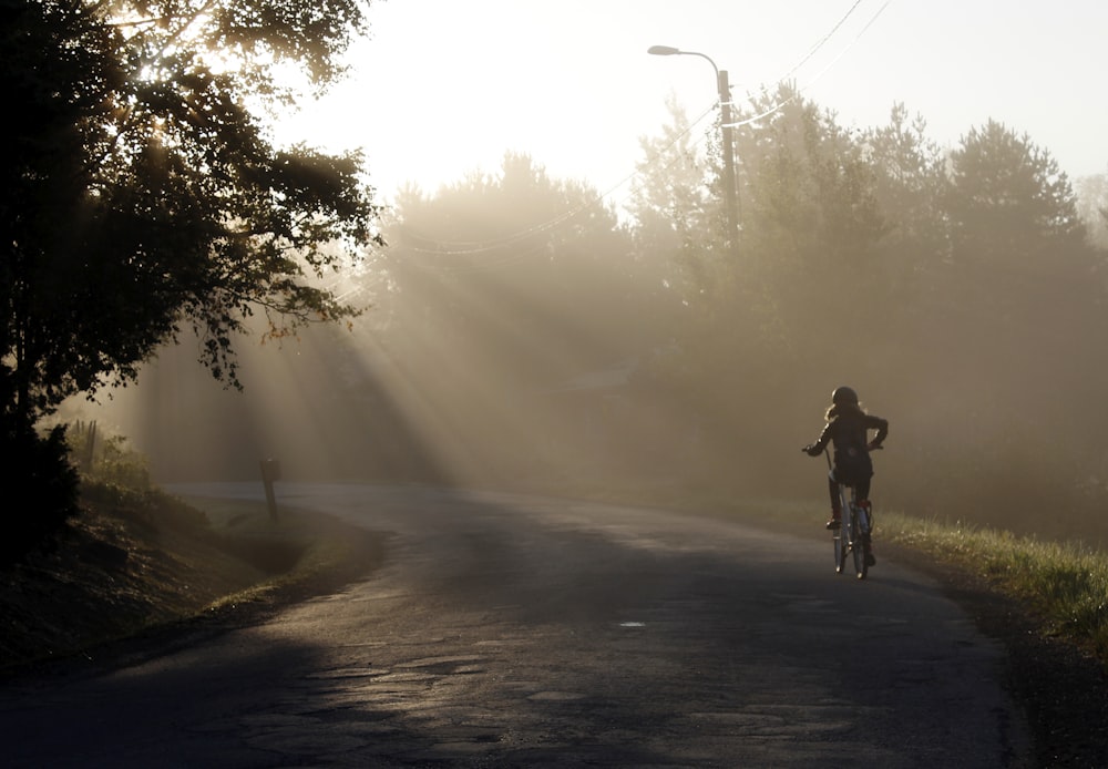 a person riding a bike down a road