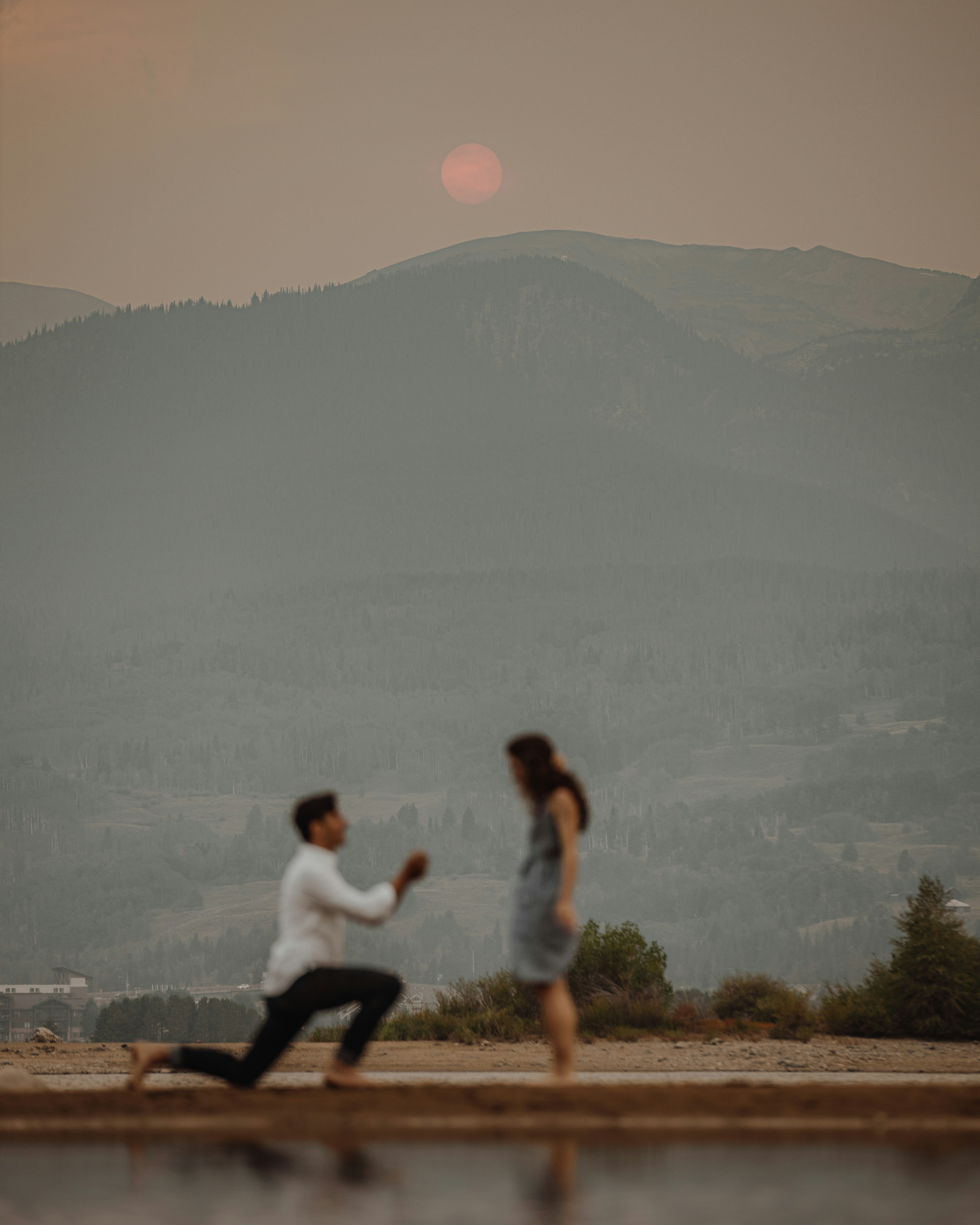 man in white shirt and black pants sitting on brown wooden bench during daytime