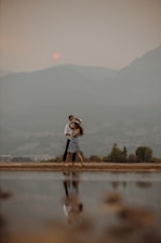 A couple enjoying a sunset shikara ride on Dal Lake surrounded by mountains.