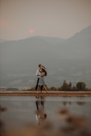 A couple enjoying a sunset shikara ride on Dal Lake surrounded by mountains.