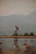 A couple enjoying a serene moment by a crystal-clear mountain lake at sunset.