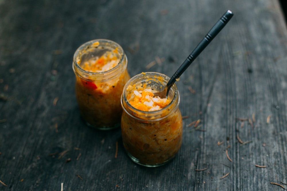 two clear glass jars with black sticks