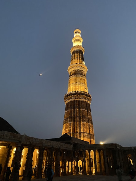 Qutub Minar, brown and white tower under blue sky during daytime