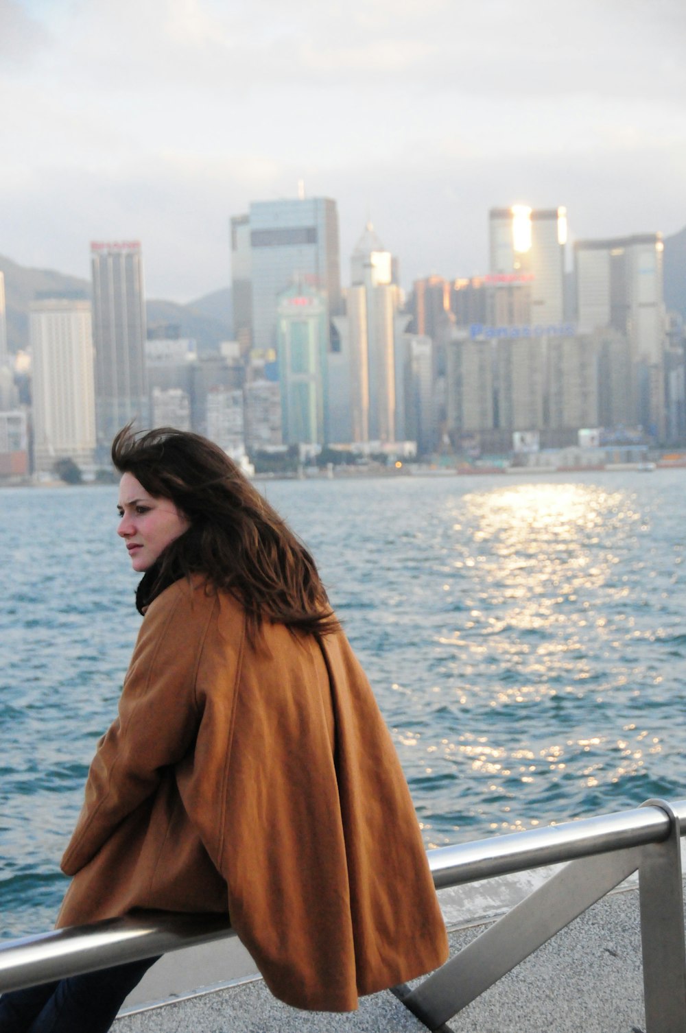 woman in brown coat standing on boat during daytime