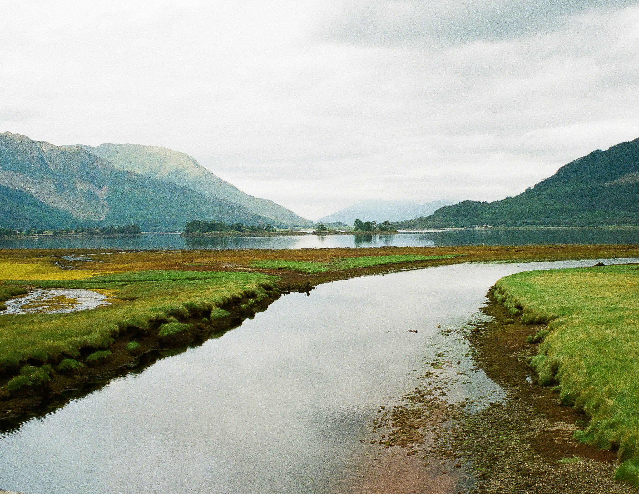 A quiet Scottish loch with mountains in the distance
