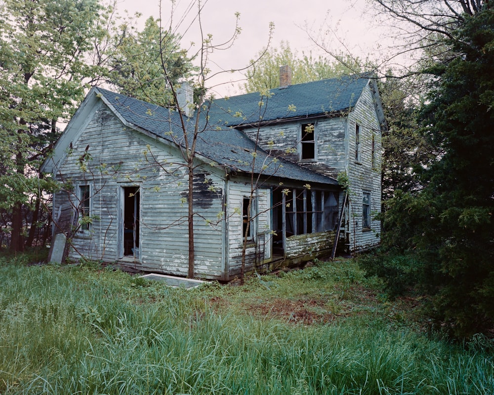 graues Holzhaus in der Nähe von grünen Bäumen tagsüber