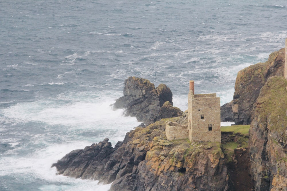 brown concrete building on cliff by the sea