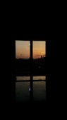 A peaceful sunset viewed through the window during a moment of trading reflection.