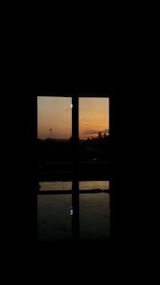 A vibrant sunset view through a window, inspiring reflection and calm.