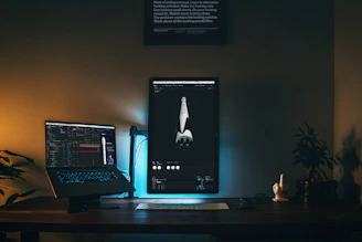 A sleek, minimalistic creator desk setup illuminated by warm orange LED lights in a dark room.