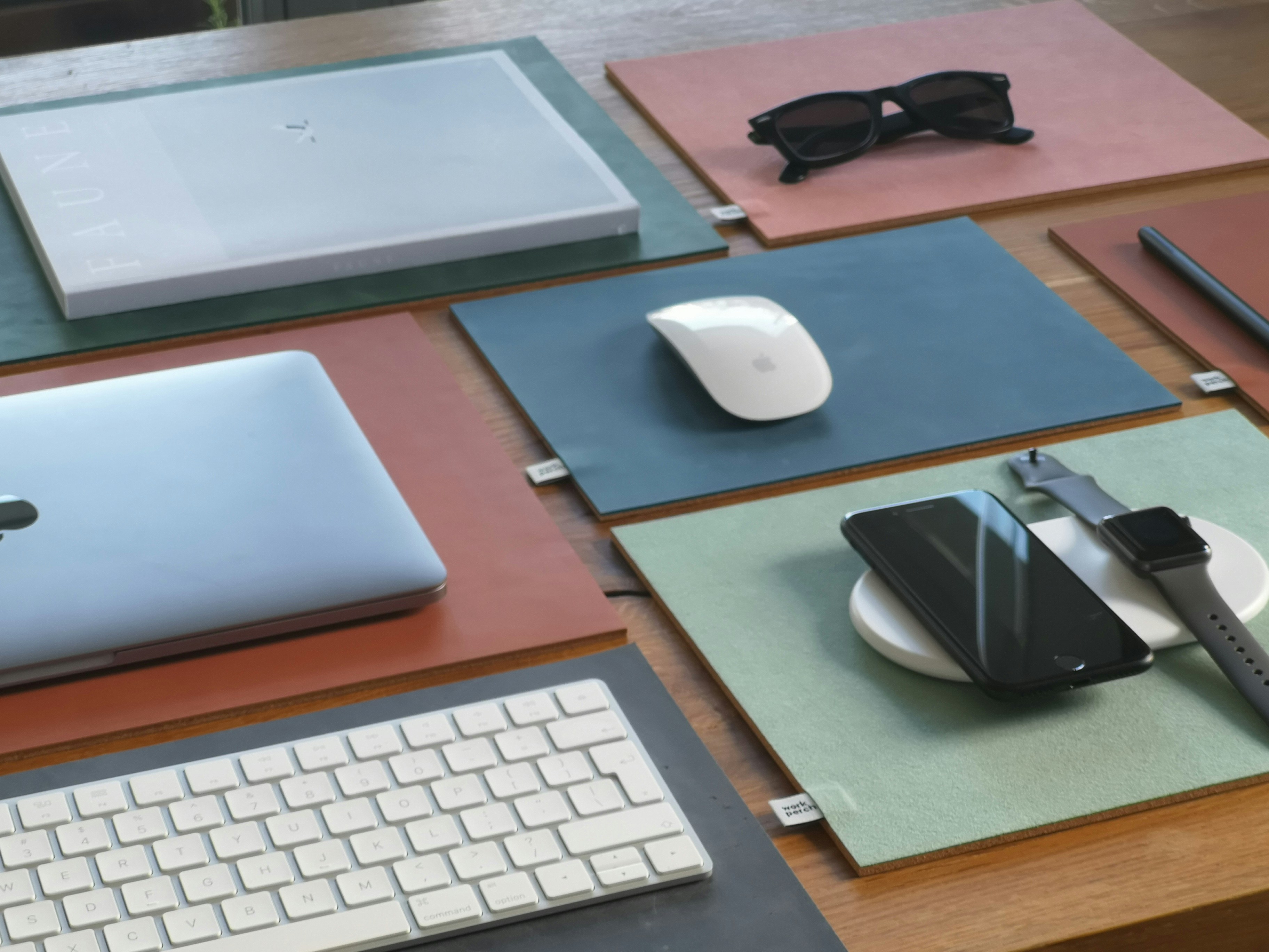 silver macbook beside black sunglasses on brown wooden table