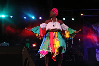 A storyteller performing on stage with expressive gestures and colorful backdrop