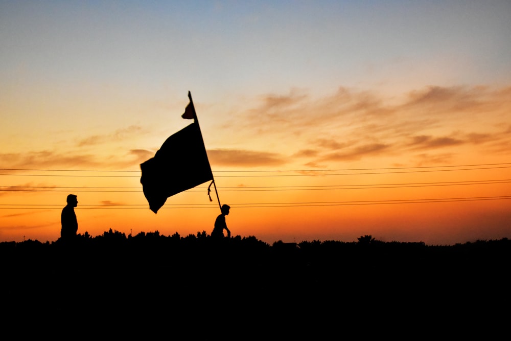 Silueta de una bandera en un mástil durante la puesta del sol