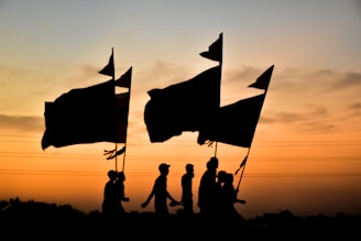 A group of Sudanese activists holding flags and banners during a peaceful rally at sunset.