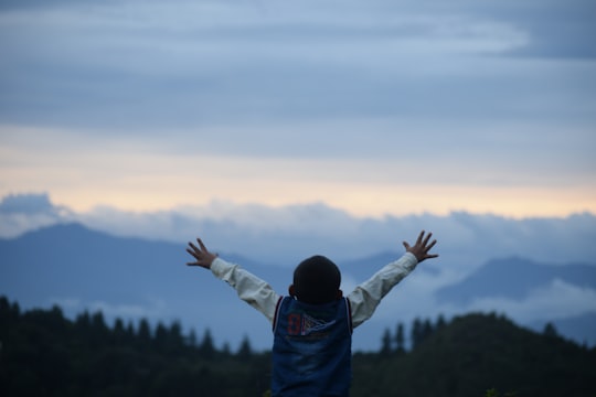 man in blue hoodie raising his hands in Pauri India