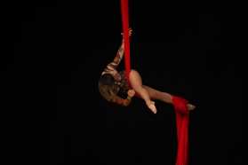 woman in red dress jumping on red pole