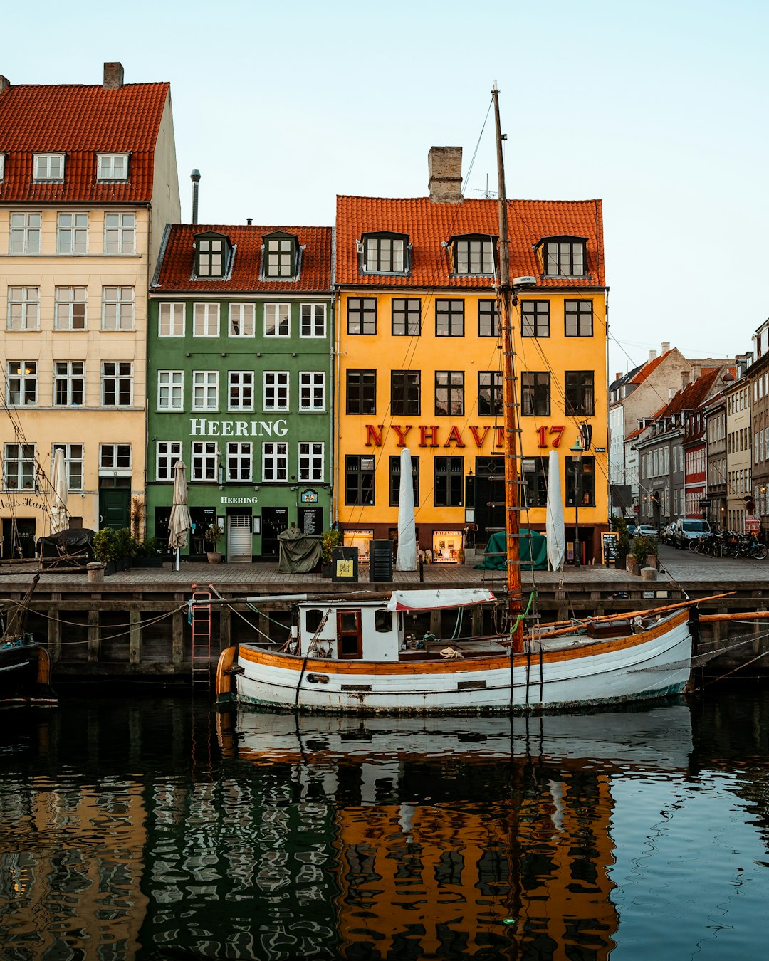 white and blue boat on water near concrete buildings during daytime