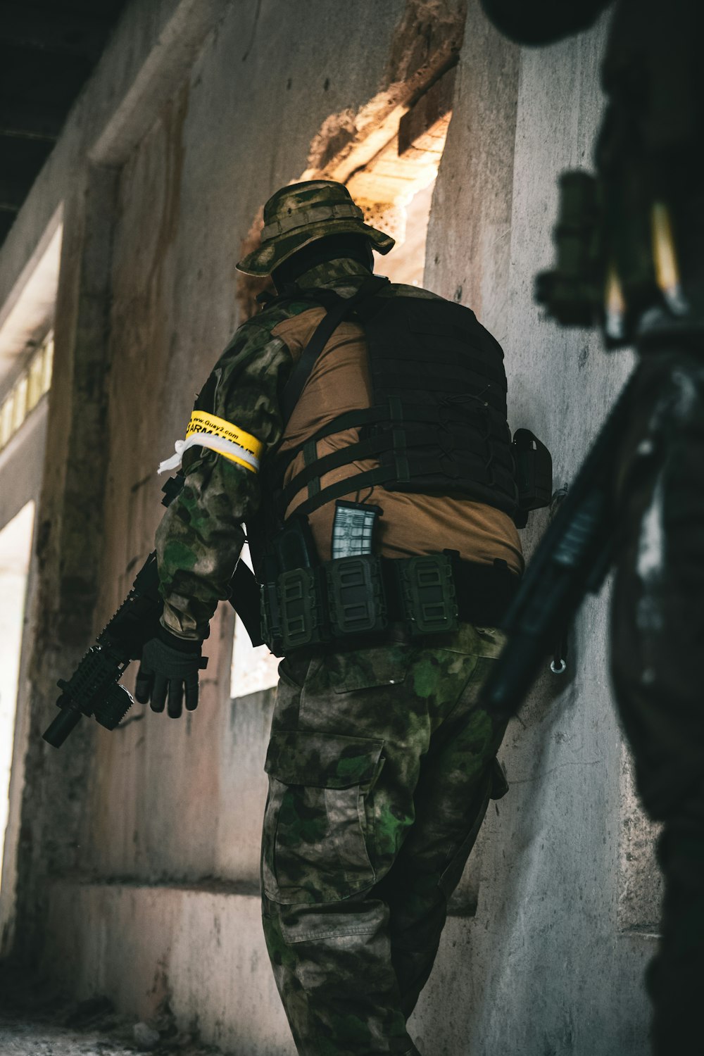 man in green and black camouflage uniform holding black rifle