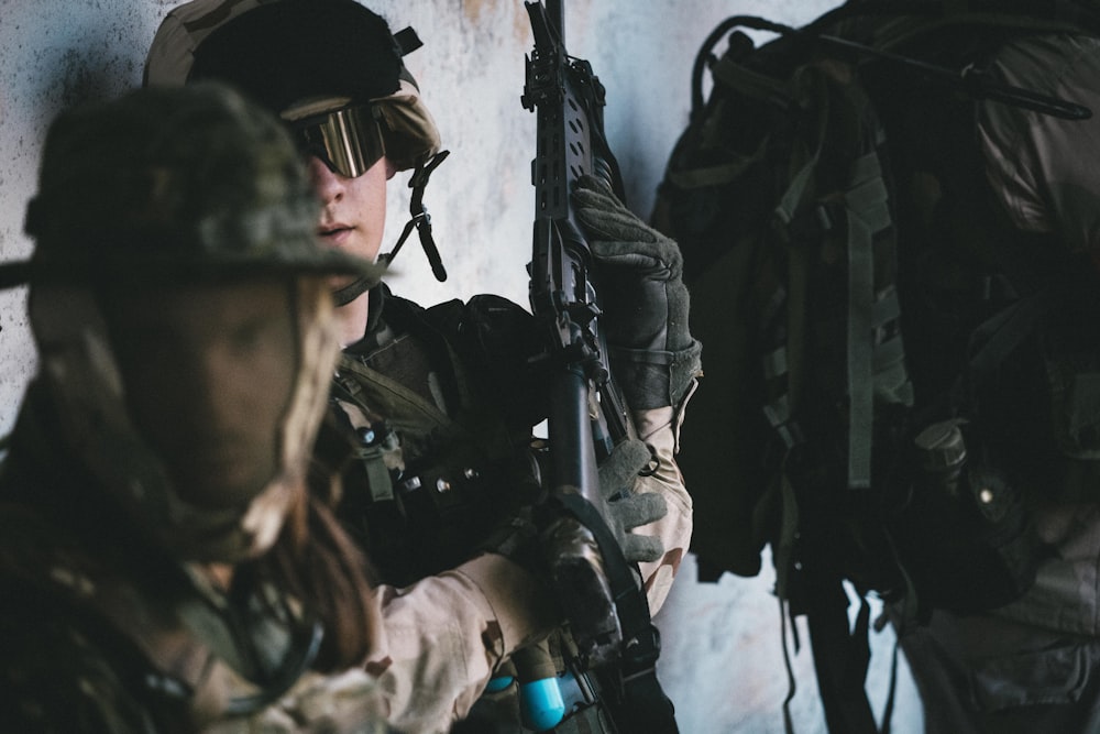 man in black helmet and black helmet holding rifle