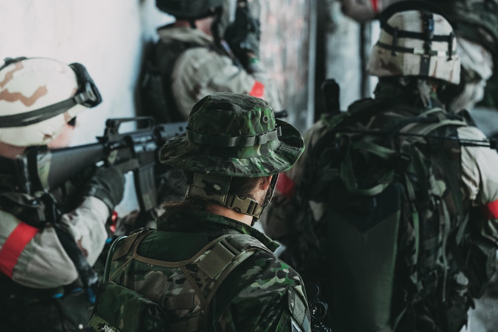 homme en uniforme de camouflage vert et noir tenant un fusil