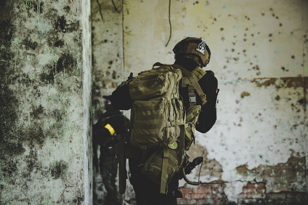 Homme en veste de camouflage marron et noir portant un casque noir