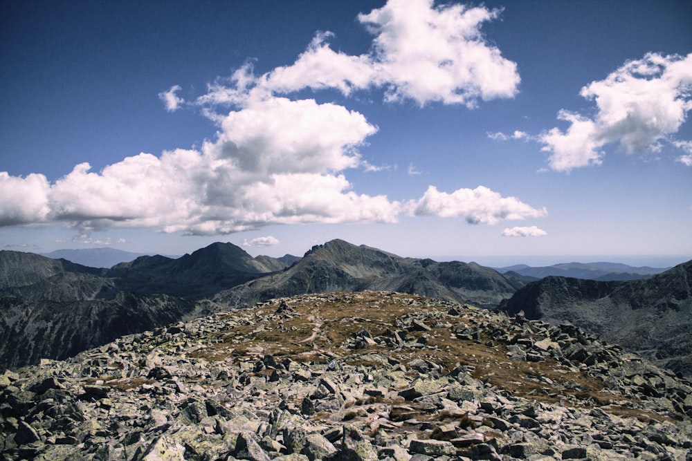 rocky mountain under white clouds and blue sky during daytime