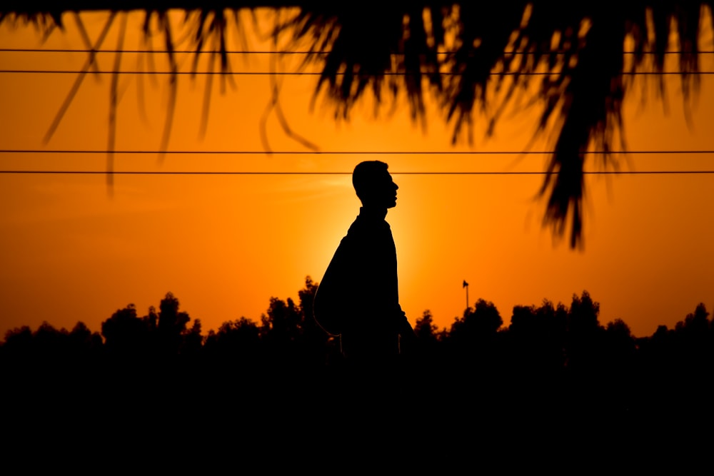 silhouette of man standing during sunset