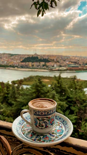 Elegant cup of coffee with Mexican ceramic design placed on a table overlooking coffee plantations and mountain ranges