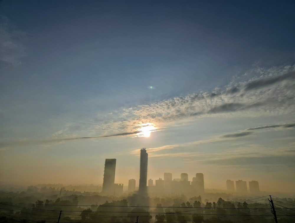 city skyline under blue sky and white clouds during daytime