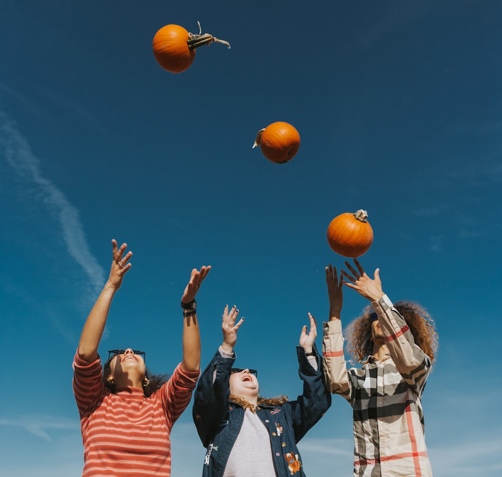 people holding orange basketball under blue sky during daytime