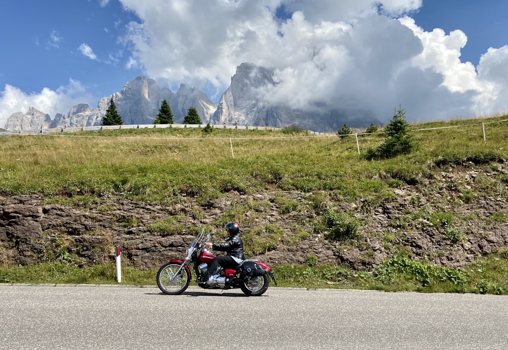 man riding on black and red motorcycle on gray asphalt road during daytime