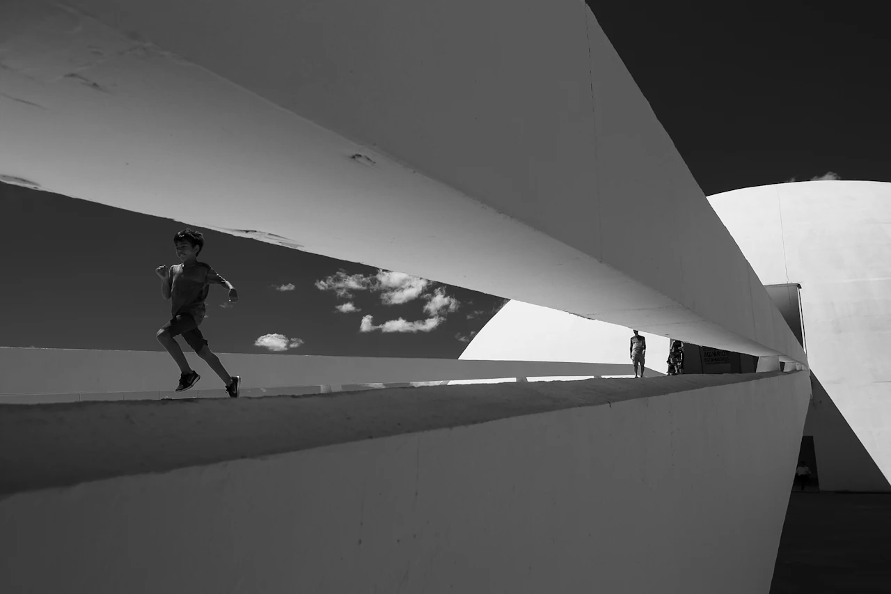 Pessoas percorrem a rampa do Museu Nacional da República, em Brasília; uma criança corre à frente.