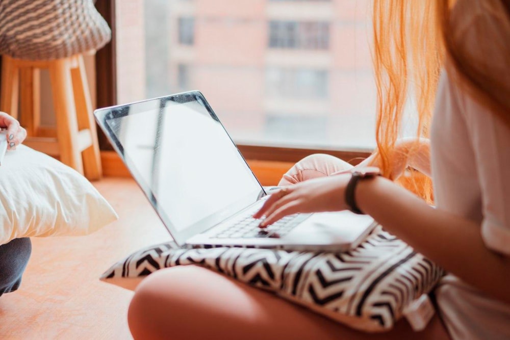 Mujer con camisa de rayas blancas y negras usando MacBook Air