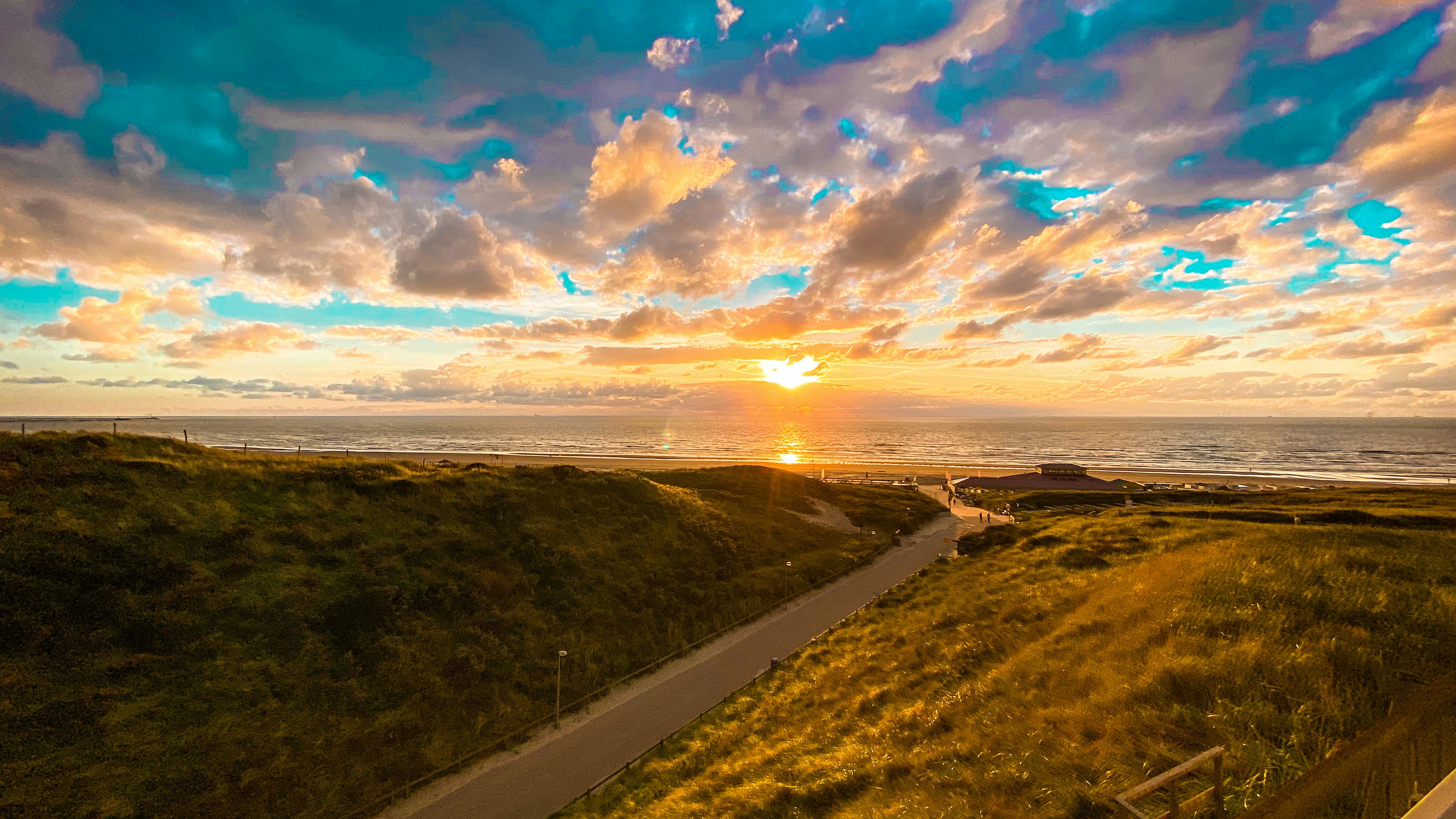 Grünes Grasfeld in der Nähe von Gewässern bei Sonnenuntergang