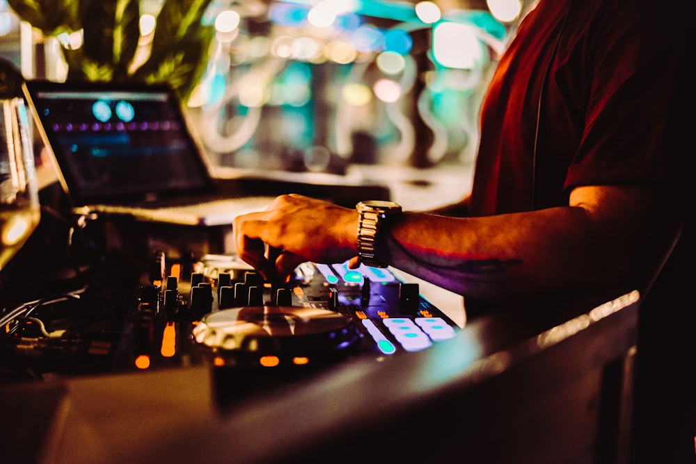 man in red t-shirt playing dj controller