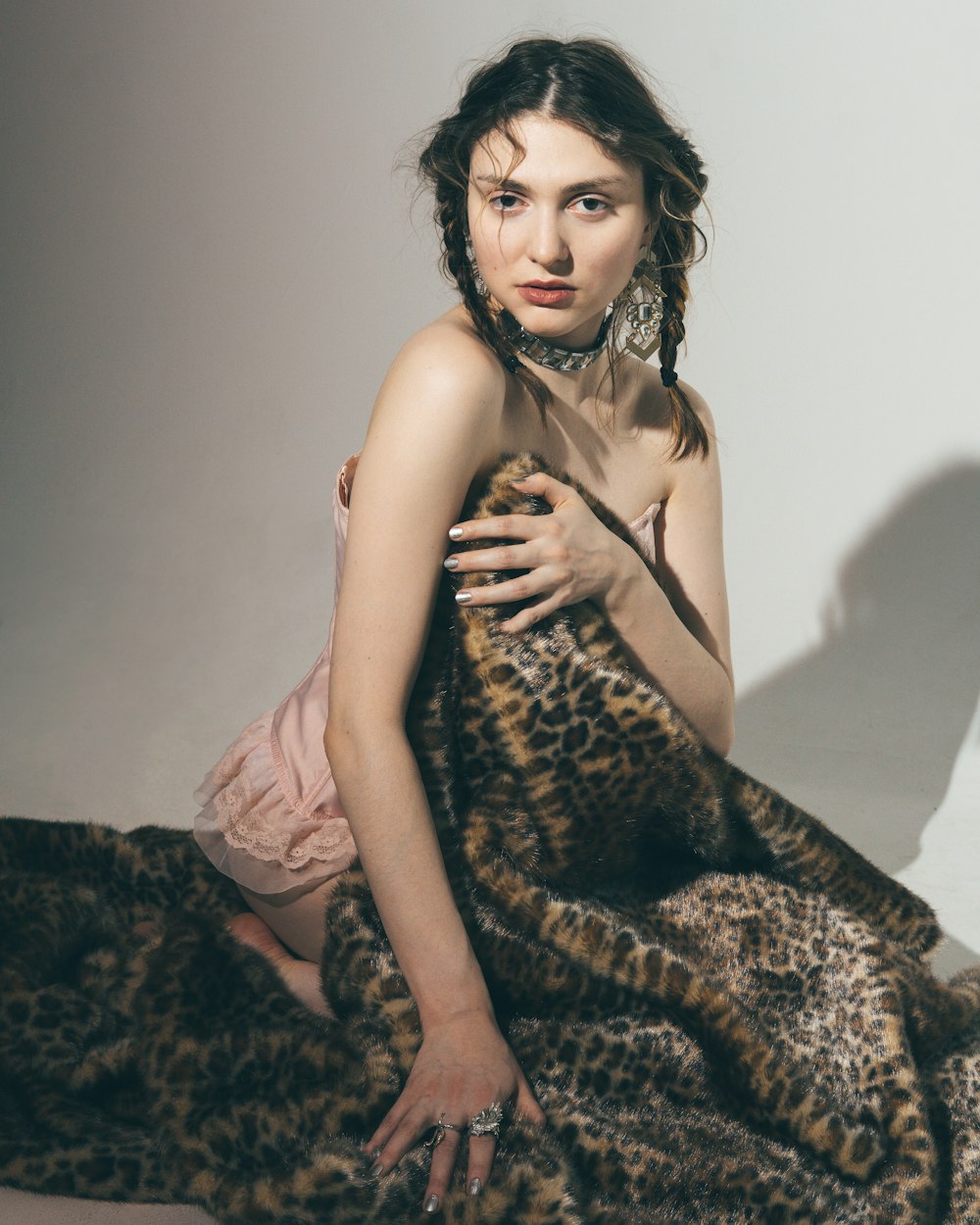 woman in brown and black leopard print sleeveless dress sitting on bed