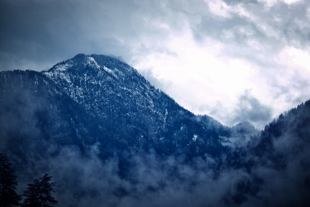 snow covered mountain under cloudy sky during daytime