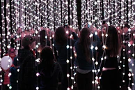 A group of friends taking photos inside the round Magic Ring photo booth with bright lighting.
